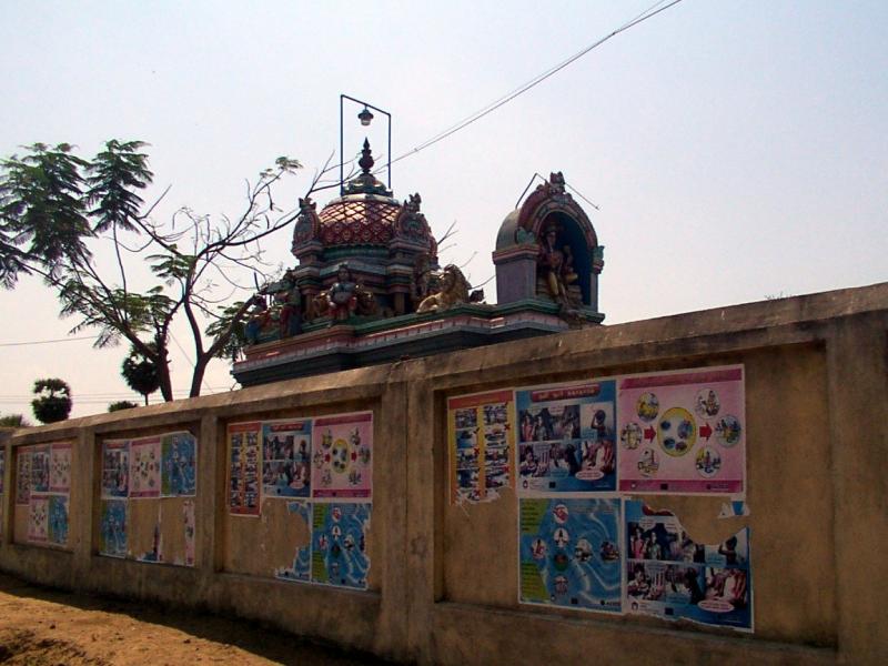 A temple wall covered in posters on WASH awareness.